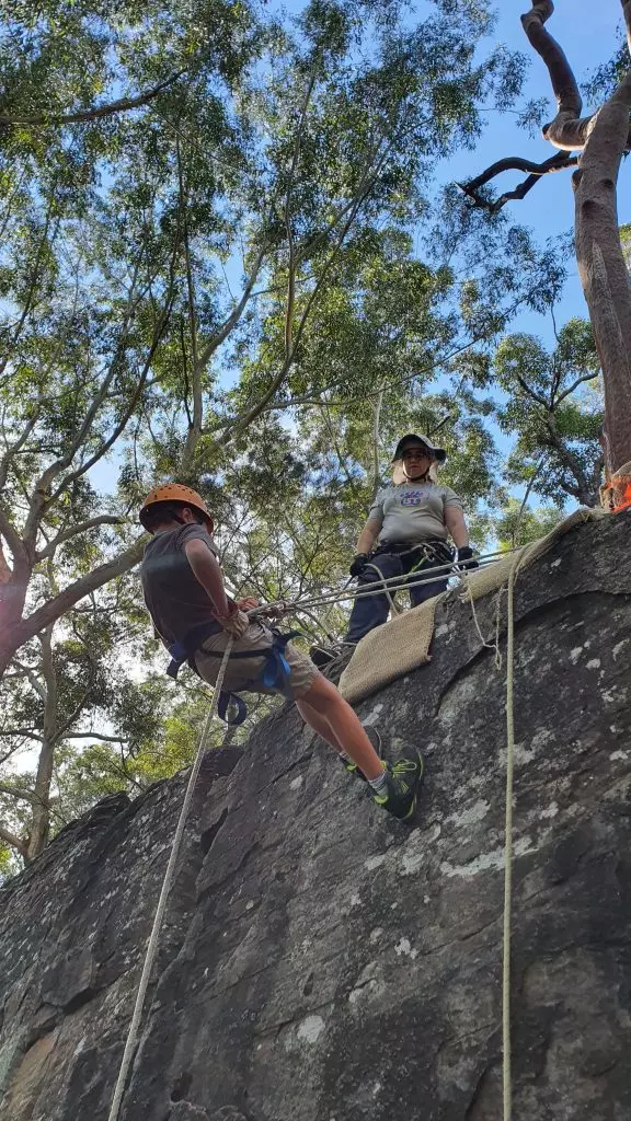 A Scout abseils on a top belay at Lindfield Rocks